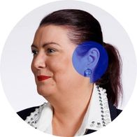 Hidden Hearing Artane clinic coordinator Anita Redmond smiling with a blue speech bubble overlayed over her ear