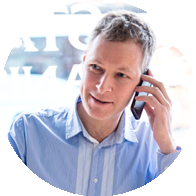A man holding a phone to his ear while seated indoors