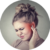 [GEN] A woman adjusts a discreet hearing aid behind her ear with one hand in a softly lit, neutral-toned setting. No brand markings are visible on the hearing device.