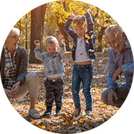 Family enjoying quality time outdoors, playing in colorful autumn leaves.