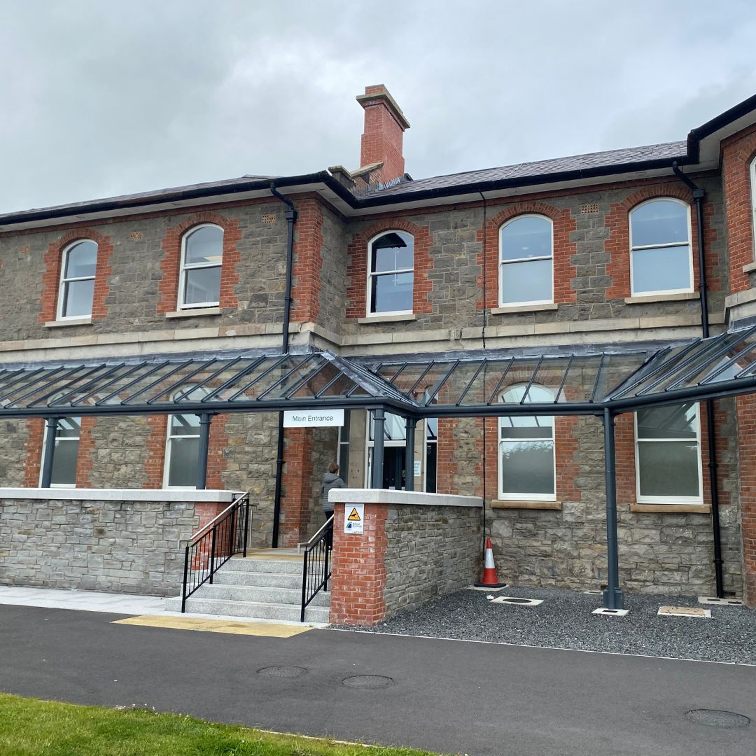 Hidden Hearing Monaghan Clinic entrance on Saint Davnet's Campus, showing a modern glass canopy and stone facade.