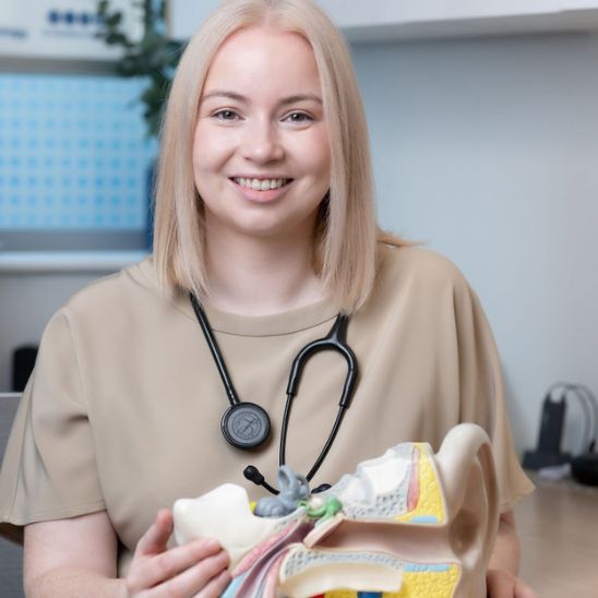 Doctor Clodagh Gallagher with a stethoscope around her neck while she holds an mould of a anatomical ear