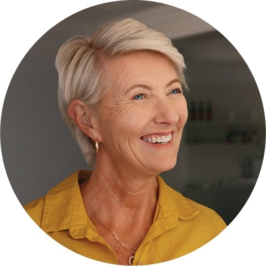 Woman in a yellow top smiling while looking very happy