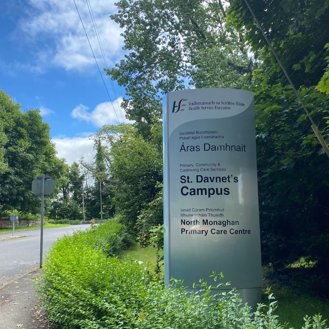 Saint Davnet's Campus sign for North Monaghan Primary Care Centre surrounded by greenery and trees.