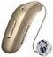 A beige Bernafon hearing aid with a sleek design, featuring a visible green indicator light and a connected transparent earpiece, designed for discreet and advanced hearing care solutions.