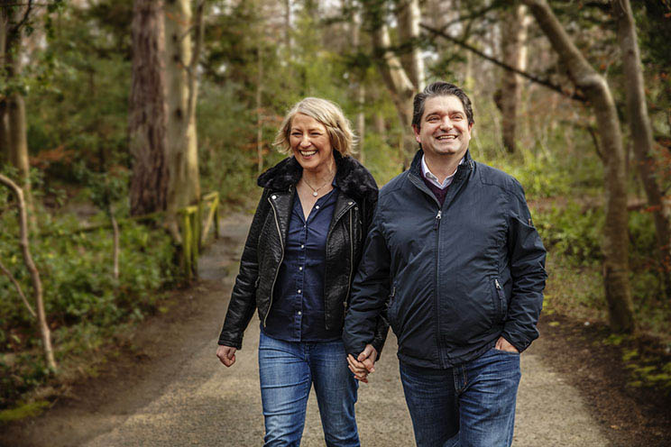 man and woman walking in the forrest