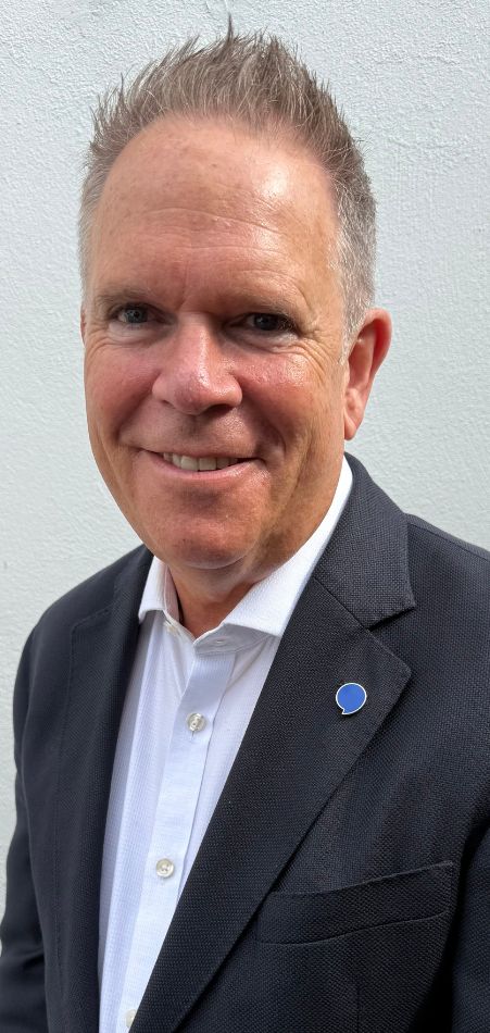 A picture of Hidden Hearing Northern Ireland's chief audiologist Tim Pringle smiling in a suit