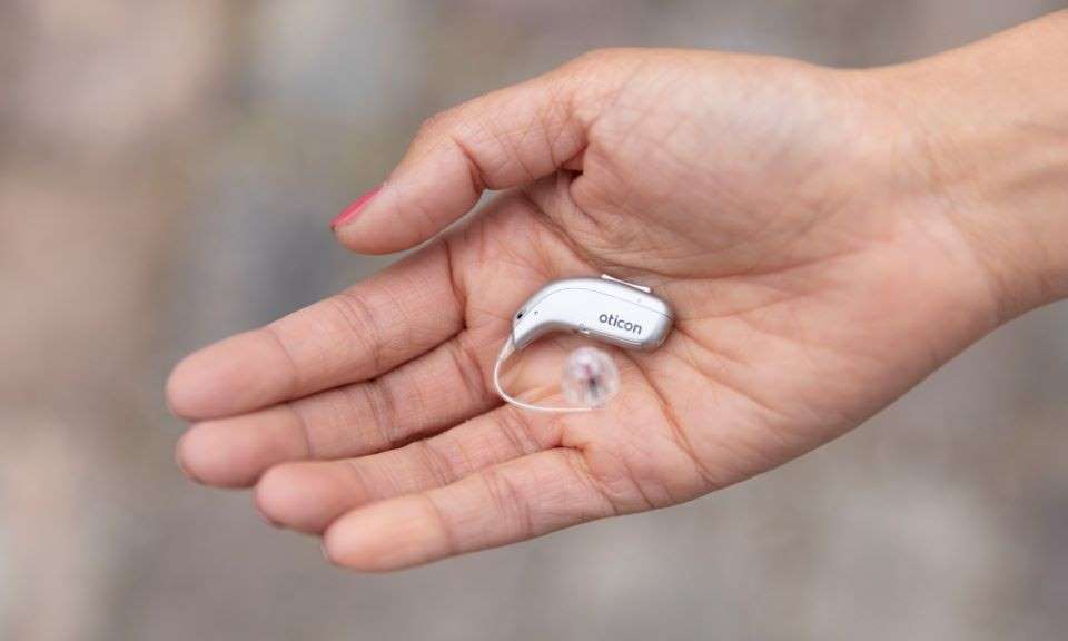 Hearing aid resting on an open palm