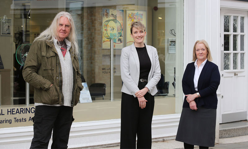 Biff Byford with hearing care professionals outside a hearing clinic.