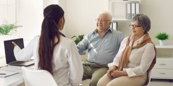 A couple consulting with an audiologist about hearing care solutions