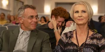 Older couple sitting together in a theater or event setting.