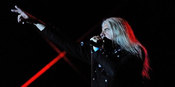 Saxon frontman Biff Byford performing on stage under dramatic lighting.