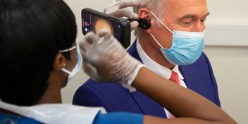 Dr Hilary Jones attending an ear wax removal procedure using modern equipment