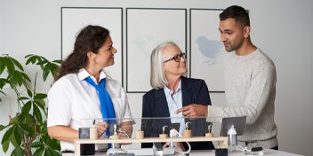 Hearing care professionals assisting a client with hearing aid options in a modern clinic setting.