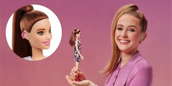 Child holding a doll with a matching hearing aid, highlighting inclusive hearing care solutions.