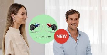 Oticon Zeal hearing aids with a modern design, featuring red and blue models, showcased between a man and woman indoors.