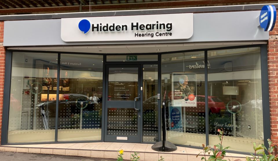 Hidden Hearing Derby clinic storefront with glass windows and a prominent sign displaying the clinic name.