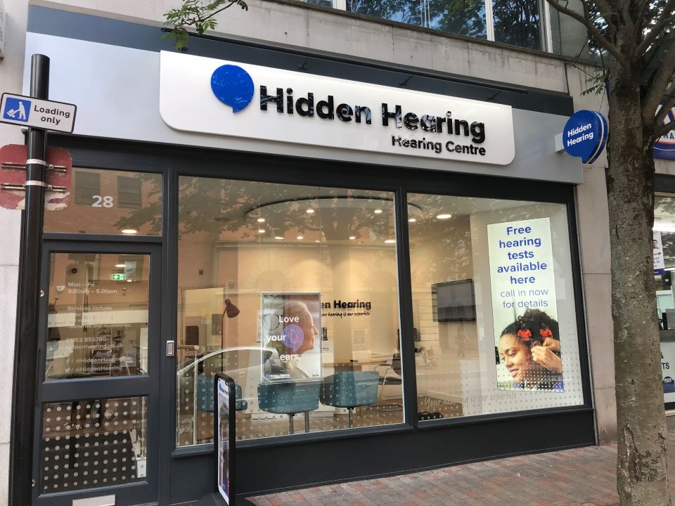 Hidden Hearing Leicester clinic storefront with large windows, visible signage, and promotional poster for free hearing tests.