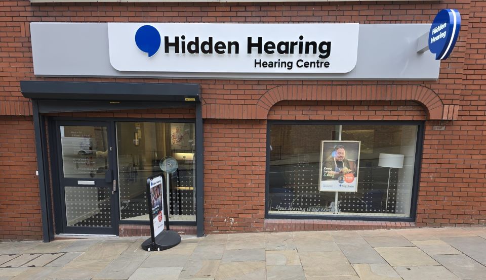Hidden Hearing Bolton clinic exterior featuring brick facade and signage
