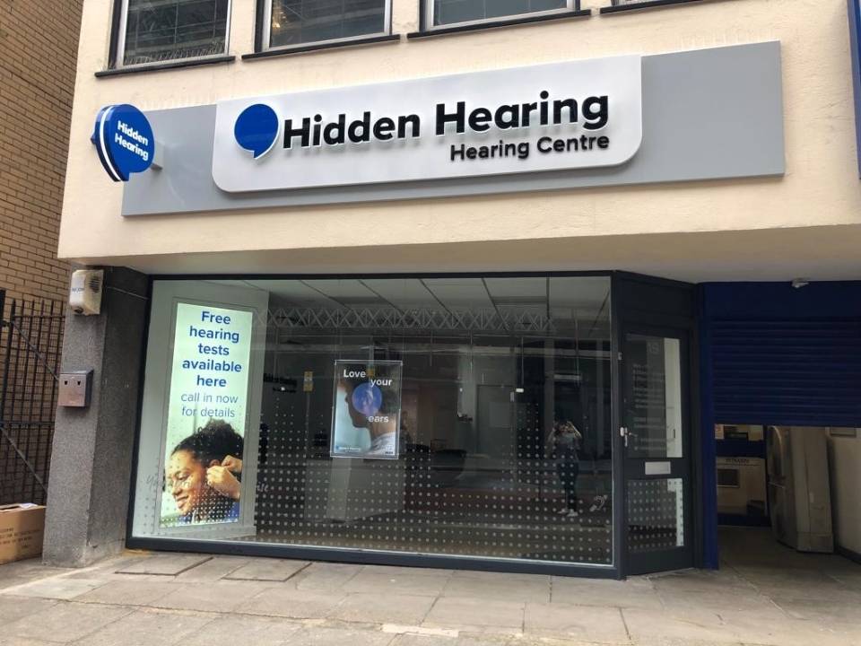 Hidden Hearing Croydon clinic storefront with signage and promotional posters for free hearing tests.