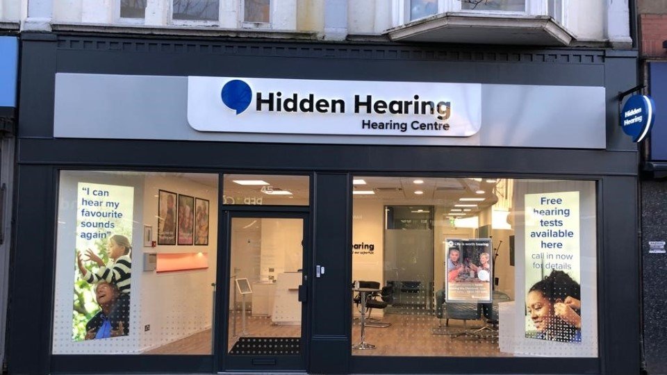 Hidden Hearing Doncaster clinic storefront with glass windows, promotional posters, and interior seating visible