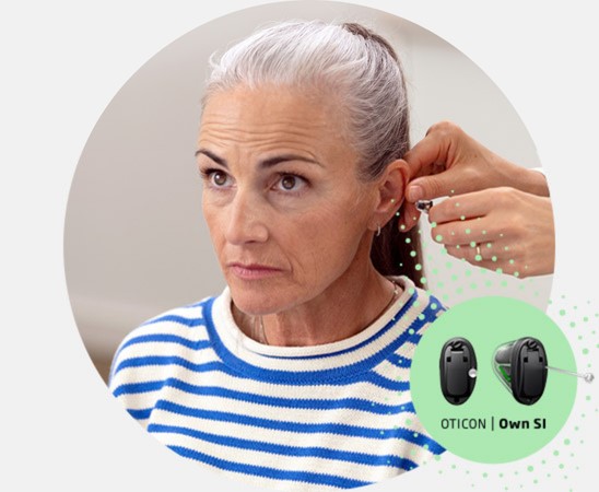 Oticon Own hearing aids are being fitted to a lady by a Hidden Hearing audiologist