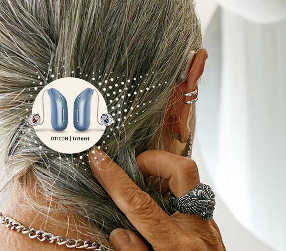A close-up shows a person with silver hair adjusting their discreet Oticon hearing aid. A circular overlay highlights 'NEW Oticon | Intent' devices, emphasizing advanced technology for hearing care solutions.