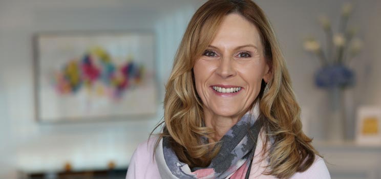 Hidden Hearing ambassador Sandra Pierce in a home setting wearing a scarf.