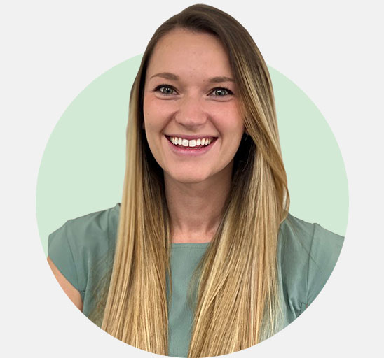 Grace Sims, hearing care specialist with long blonde hair wearing a green blouse.