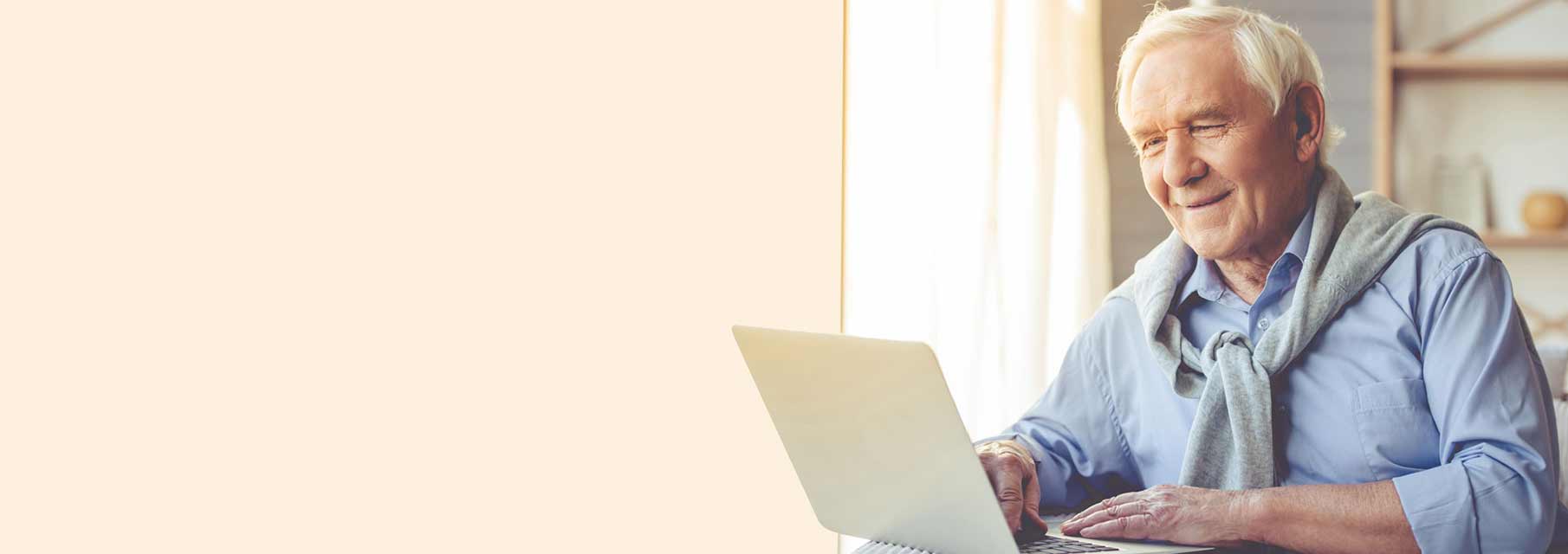 Image shows man looking for frequently asked question about hearing loss and hearing aids on his computer