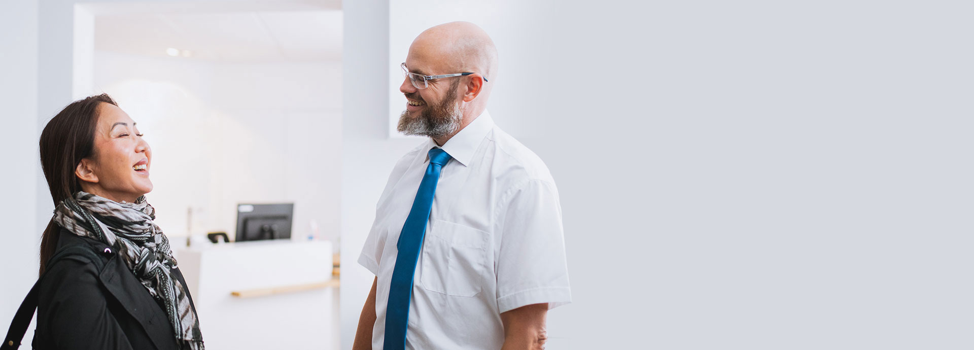 Hearing care expert consulting with a customer in a modern clinic setting.