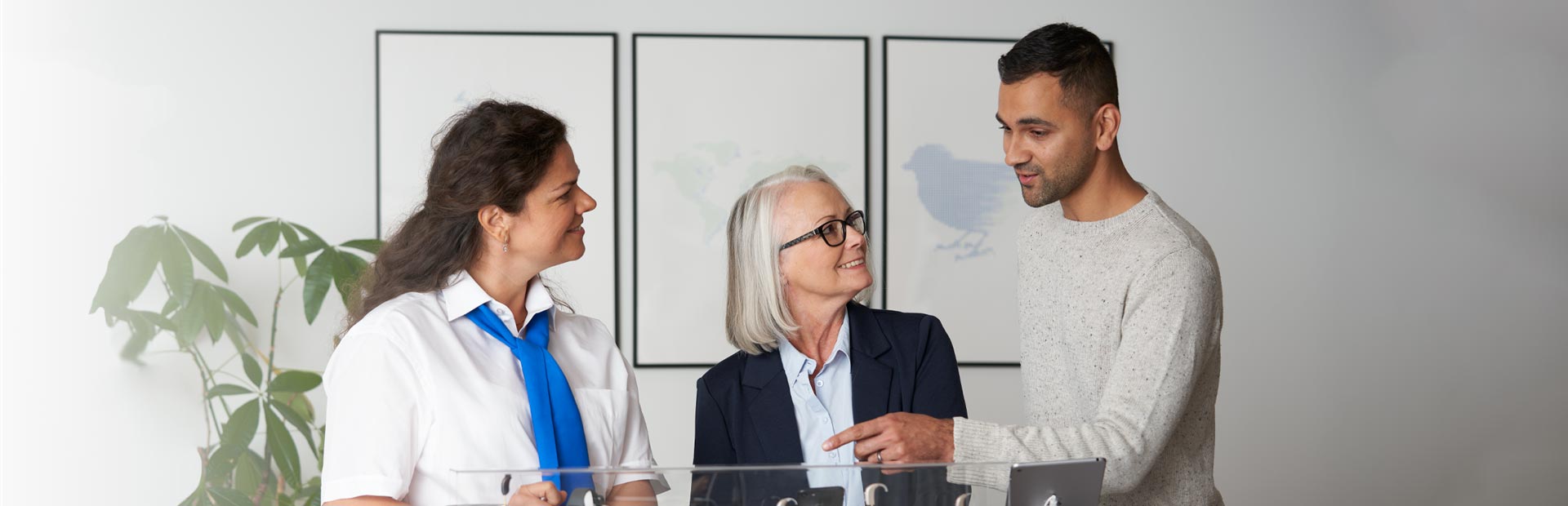 Image shows Hidden Hearing customers discussing hearing aid accessories with a hearing care expert