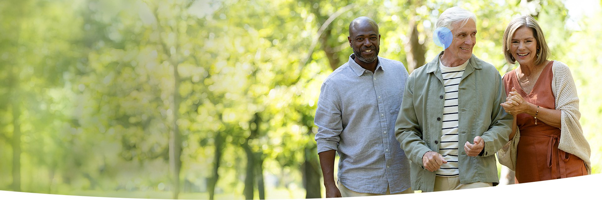 Group of people outdoors, enjoying a walk in a peaceful green park, highlighting healthy living and social connection.