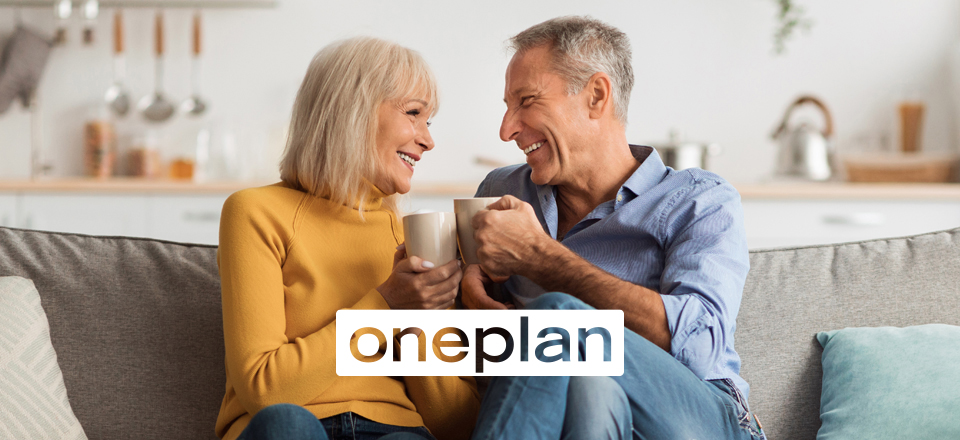 Couple sitting on a couch in a cozy living room, drinking coffee with the Oneplan logo in the foreground.