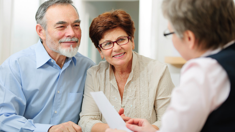 Image shows a couple talking to a hearing care expert about the levels of hearing loss