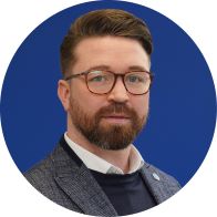 Hearing care professional in formal attire with a blurred face against a blue background