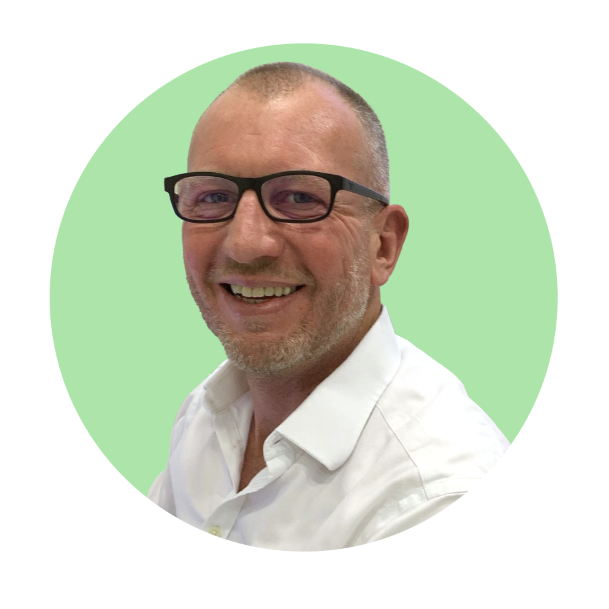 Hearing care specialist wearing a white shirt against a green background