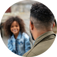 Man wearing a digital hearing aid while speaking to a woman outdoors.
