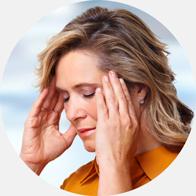 Woman experiencing tinnitus symptoms, holding her hands to her head.