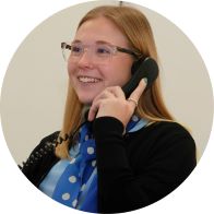 Hidden Hearing business coordinator speaking on the phone while wearing a blue polka dot scarf.