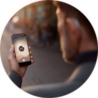 Man adjusting digital hearing aids via a smartphone using Bluetooth technology.