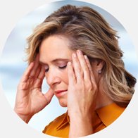 Woman experiencing tinnitus symptoms, holding her hands to her head.