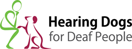 The logo features a green stick figure person kneeling and interacting with a maroon stick figure dog. Text to the right reads: 'Hearing Dogs for Deaf People.'