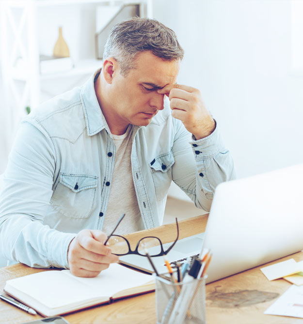 Image shows a man suffering whilst working from tinnitus