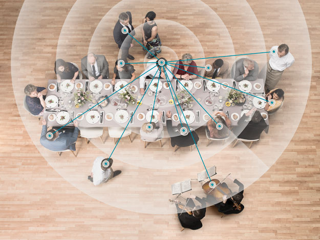 Illustration of brain hearing technology focusing on individual speech sources in a lively social gathering.