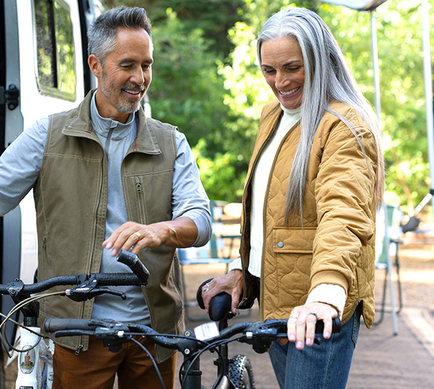 A couple preparing their bikes for an outdoor activity.