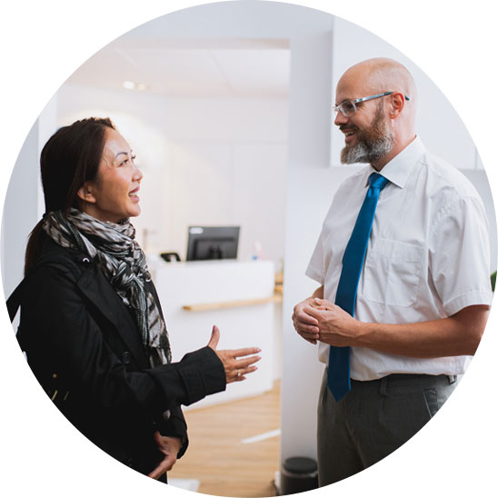 Image shows a hearing care expert talking with a customer