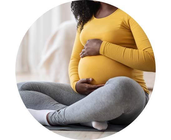 Pregnant woman cradling her belly, representing the potential genetic factors of congenital hearing loss.