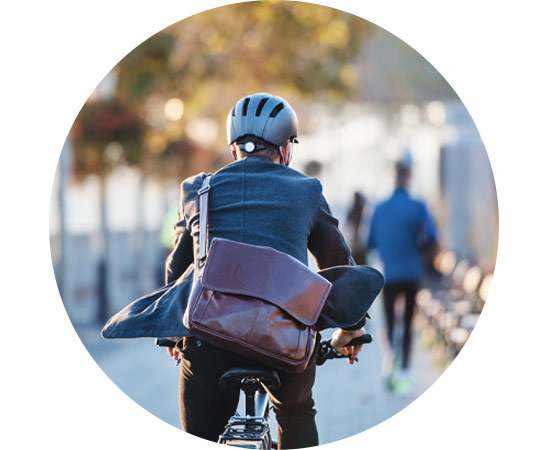 Cyclist commuting with a leather satchel, promoting Hidden Hearing's cycle scheme.