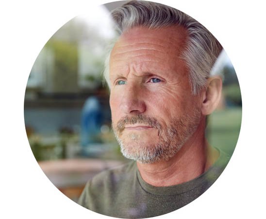 Man experiencing social anxiety linked to hearing loss in a blurred background setting.